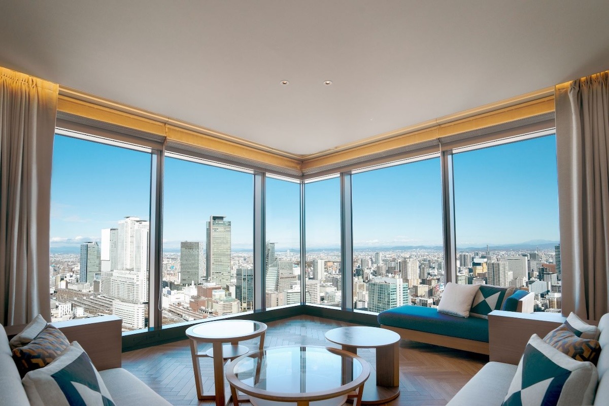 Interior view of a luxurious hotel room with large windows offering panoramic city views in Nagoya.