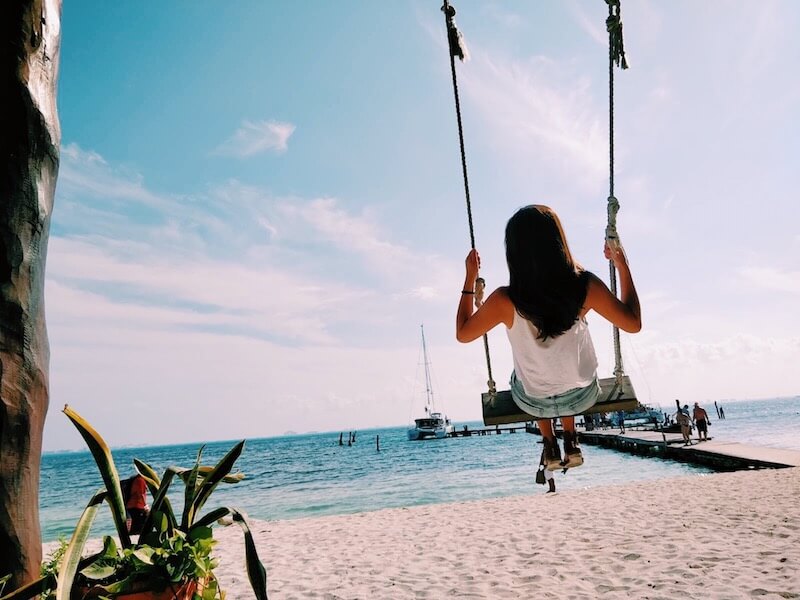 girl on swing at beach
