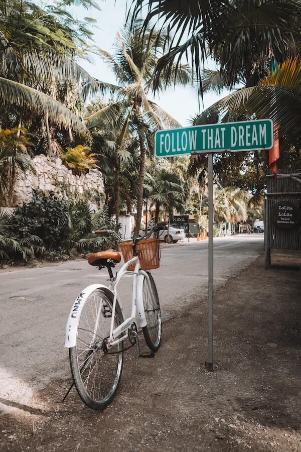 Follow That Dream sign in Tulum, Mexico with bicycle