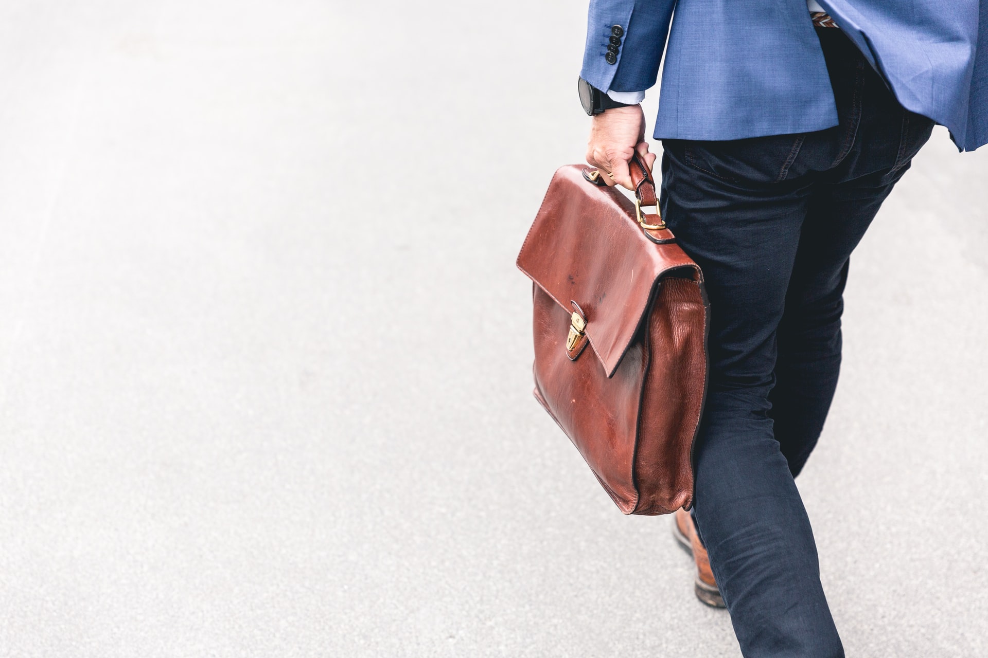 man carrying brown leather work bag