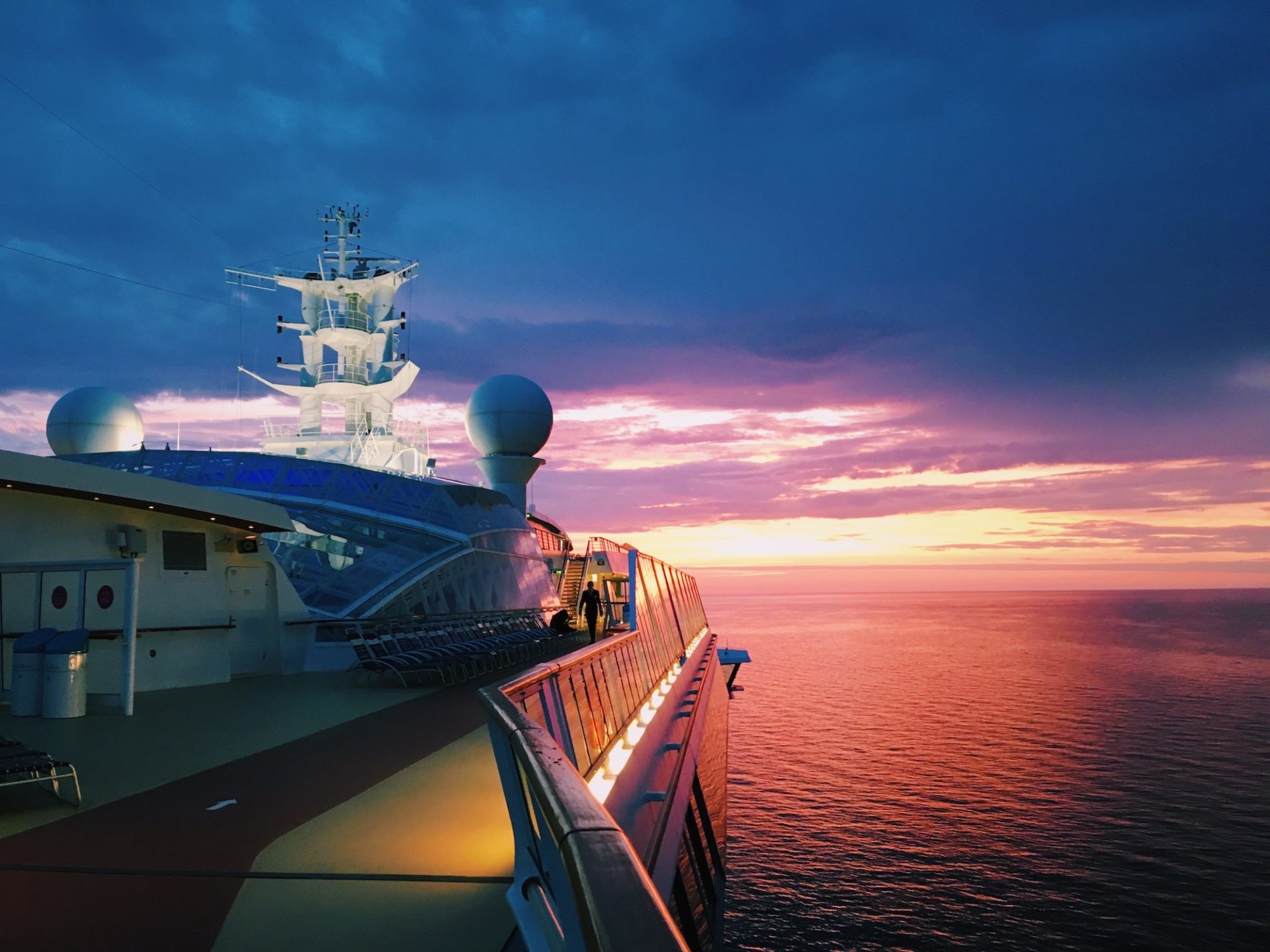 open top deck of cruise ship at sea during pink and purple sunset
