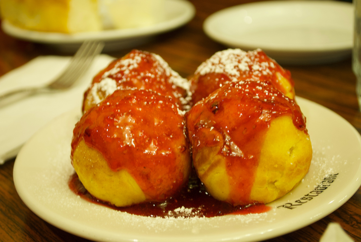 four aebleskivers on a plate with red sauce