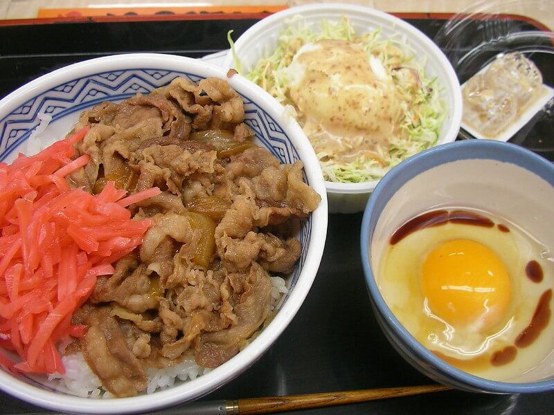 japanese meal gyudon set with a raw egg and simple salad