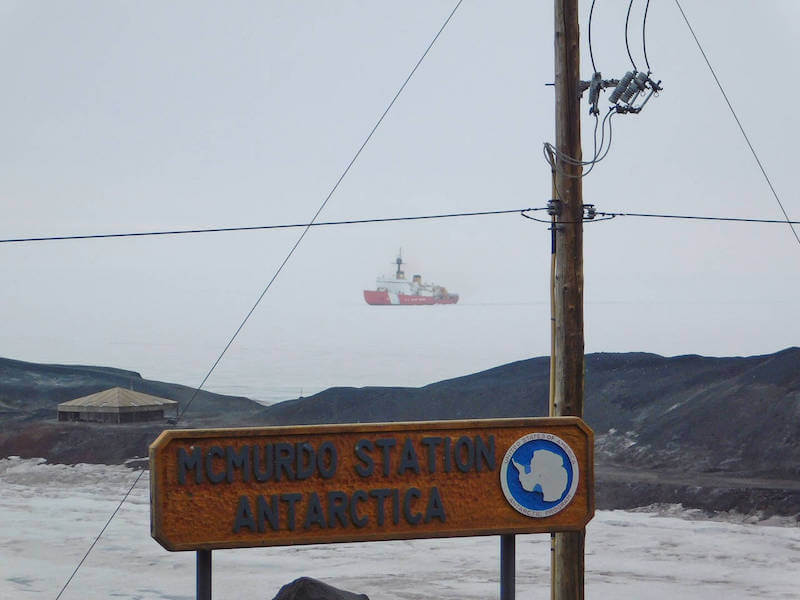 McMurdo Station Antarctica sign, power line, and ice breaker