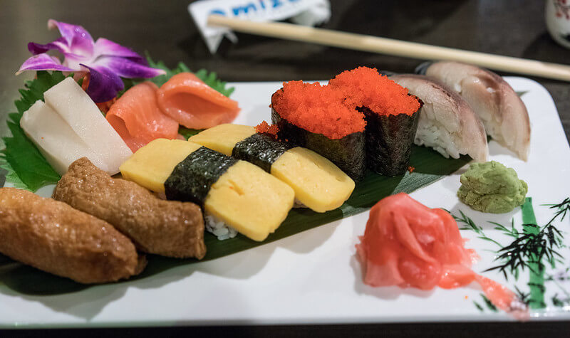 one of the 50 most popular japanese food, sushi, presented on a platter with ginger and wasabi