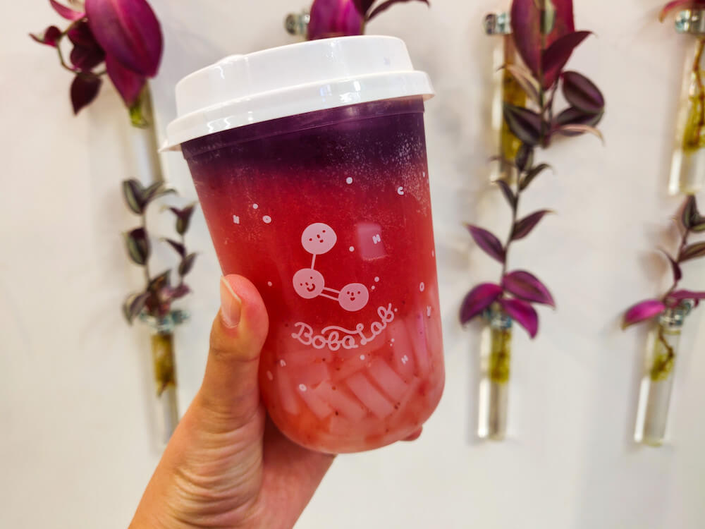 Berry Nebula from BobaLab, a magenta based tea with purple pea tea on top with lychee at the bottom