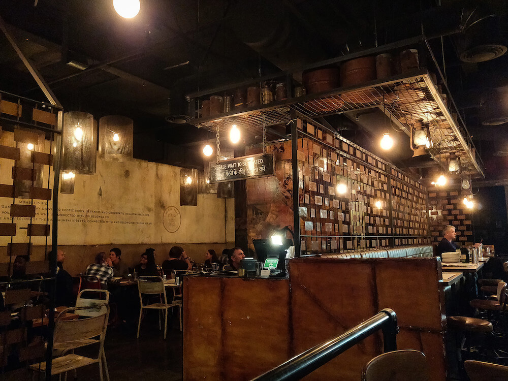 Interior of Mumbaiwala Restaurant in Christchurch-- mimics the atmosphere of street stalls in Mumbai. Dark interior with walls painted to look weathered, dimly lit
