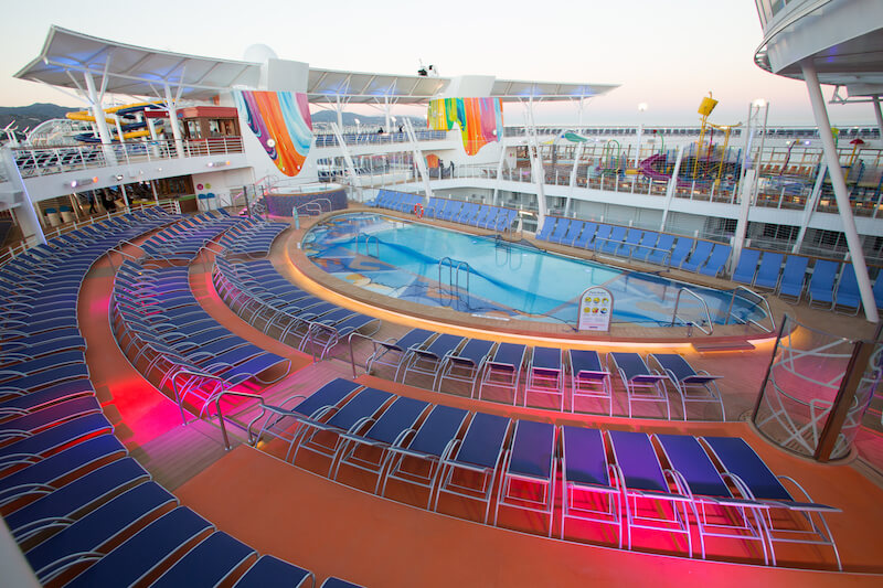 The main pool deck of Royal Caribbean's Symphony of the Seas. Includes lounge chairs and ambiance lighting after sunset