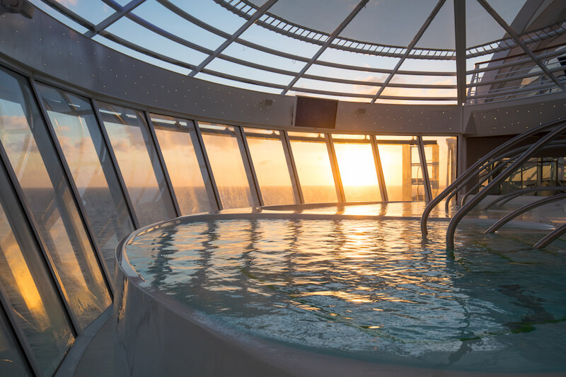 The hot tub inside Symphony of the Seas' Solarium featuring floor-to-ceiling windows