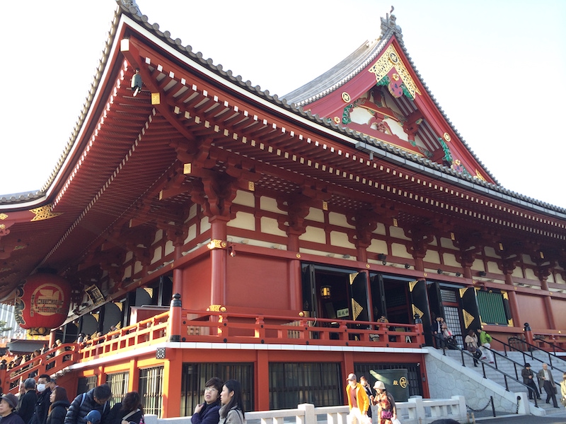 Sensoji temple in Tokyo Japan. The exterior is red with a large lantern at the entrance