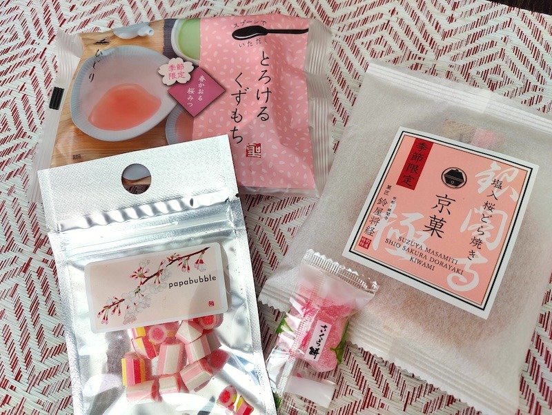 Wrapped items from a Sakuraco box: kuzumochi, dorayaki, sakura candy, and sakura mochi