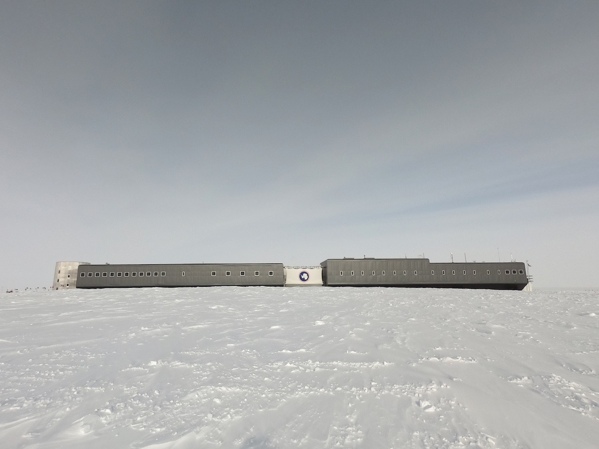 Amundsen-Scott South Pole Station-- a long, gray, rectangular building sits among ice.