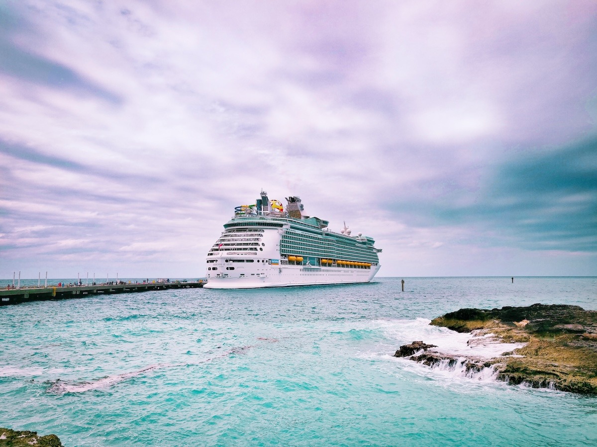 Mariner of the Seas docked at CocoCay, Bahamas. The ship sits under a cloudy sky with turquoise waters below.
