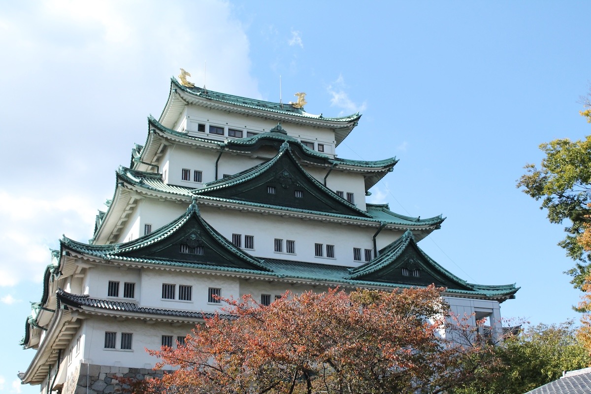 Nagoya Castle surrounded by trees with varying shades of autumnal red and orange