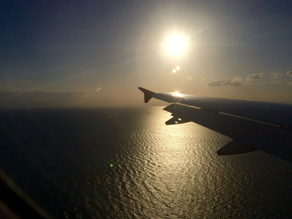 airplane over water in sunset