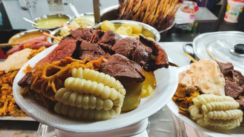 A plate of anticucho, choclo, and potatoes