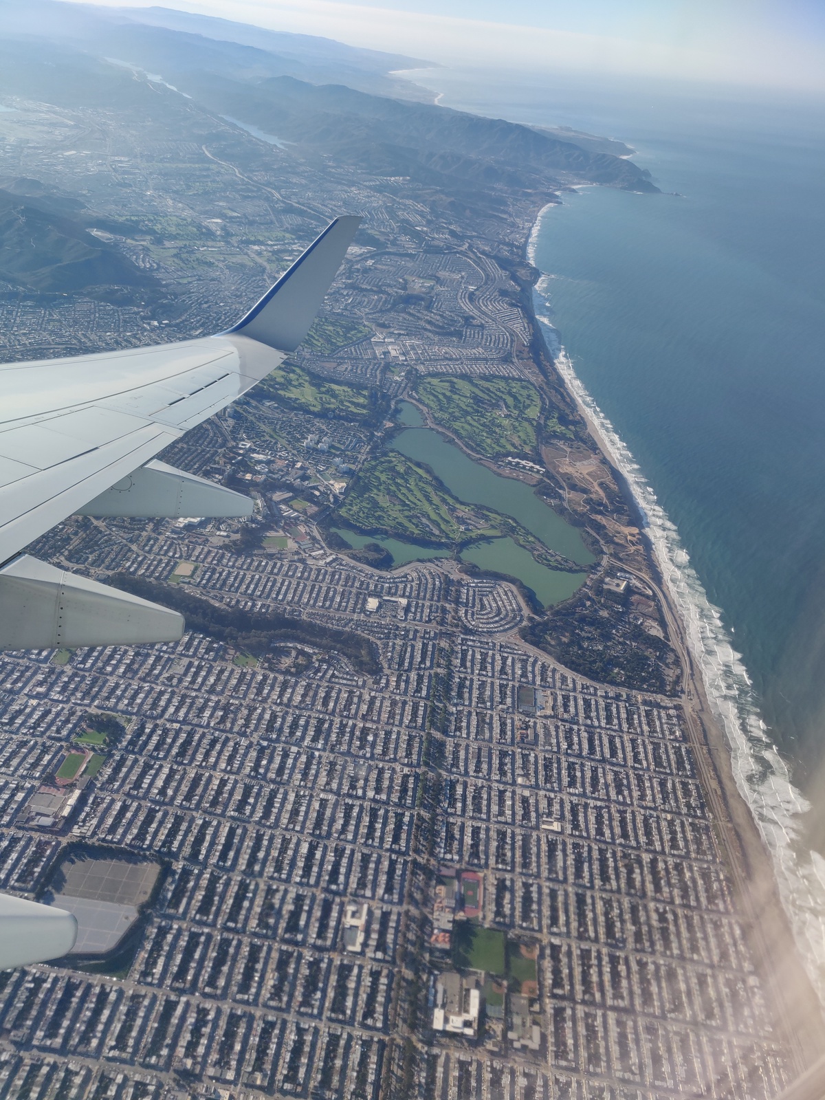 aerial photo above Cancun with part of airplane wing