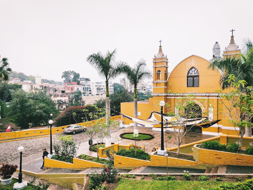 yellow building with terraced platforms also painted yellow and lined with greenery