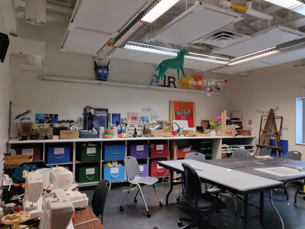 The craft room at the South Pole. Pictured: a couple of large tables, sewing machines, remnants of projects in progress, and boxes of craft supplies and materials