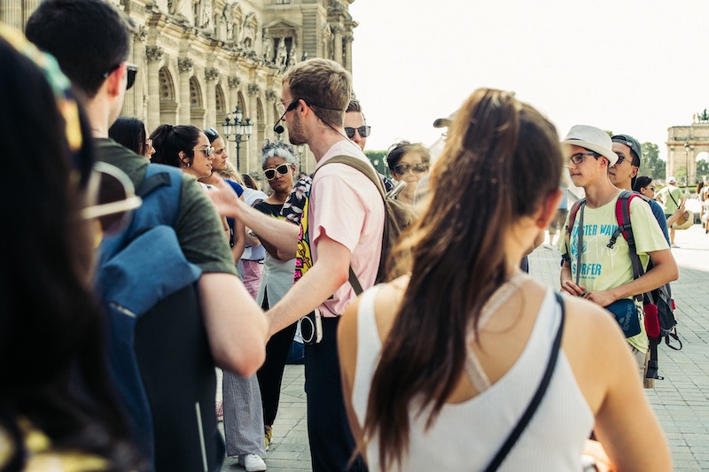 A tour guide with a headset microphone talks to a group of people