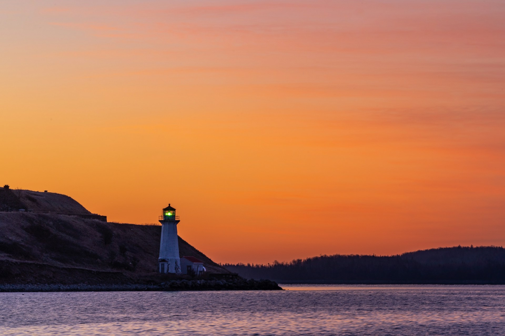 An orange sunset with a lighthouse